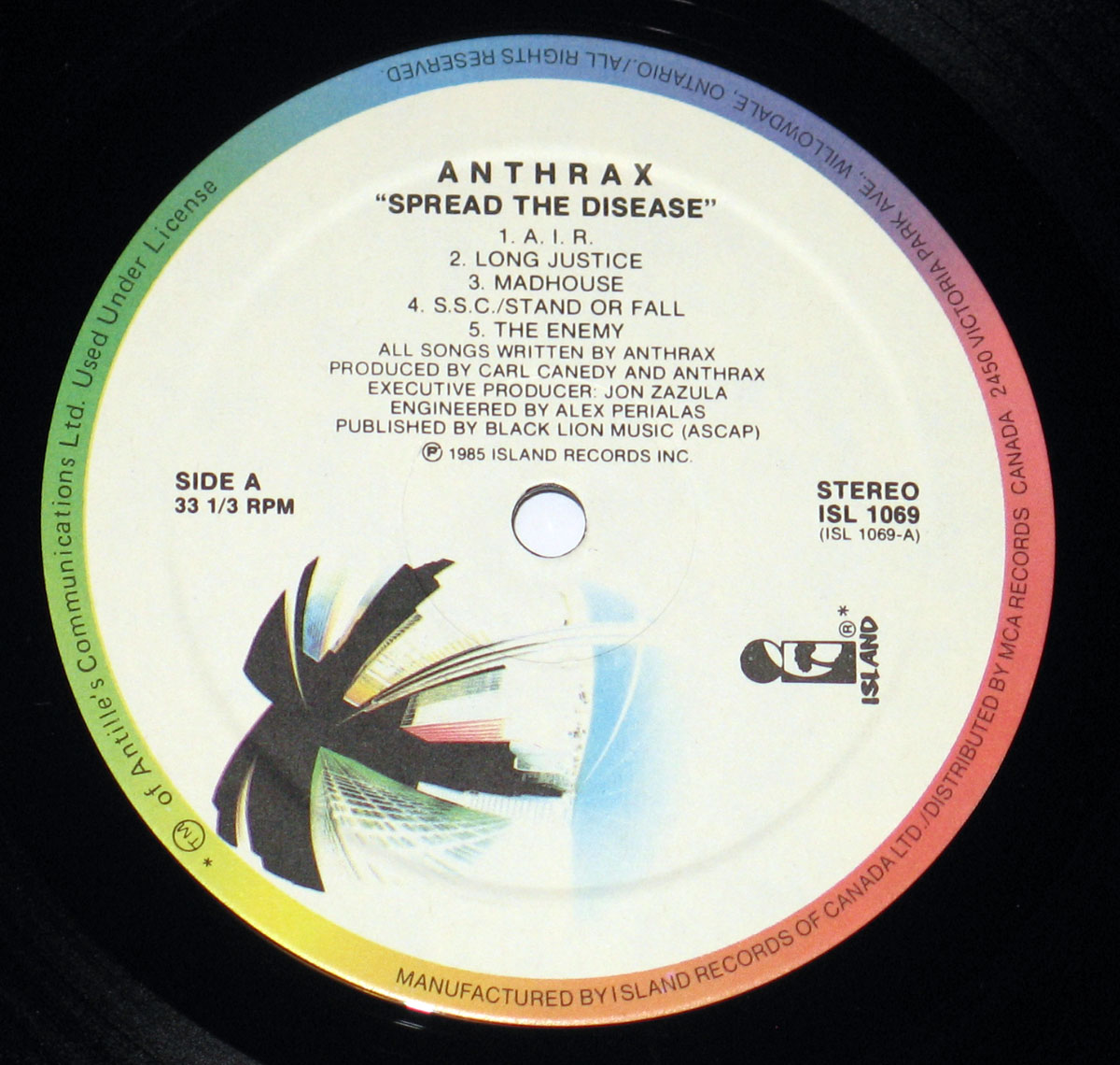 Close-up of Side A record label from Anthrax's 'Spreading the Disease' album, released by Island Records. The label features the album title misprinted as 'Spread the Disease,' with a gradient color background, tracklist, production credits, and the Island Records logo.